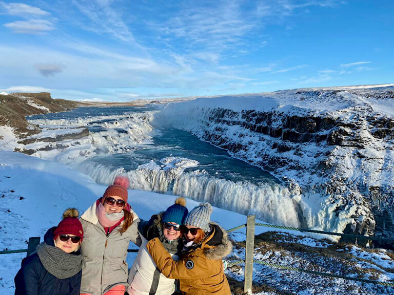 Picture of tourists at Gullfoss Waterfall in synny, wintery day.