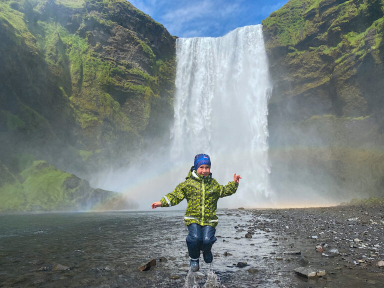 My guests child by the Skógafoss waterfall in Iceland, with a rainbow. Part of the South Coast Tour by Arctic Mike Iceland.