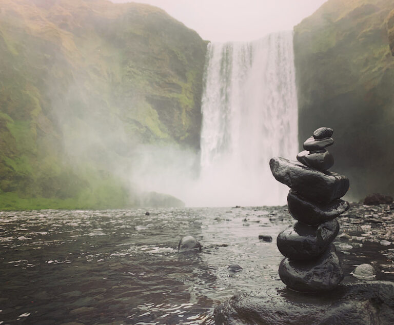 Skógafoss waterfall in Iceland. On the first plan, the rock formation. Part of the South Coast Tour by Arctic Mike Iceland.