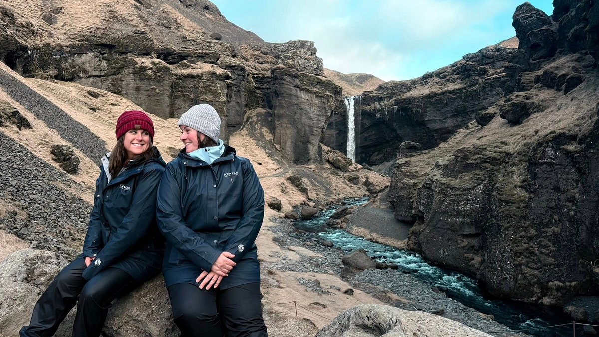 A couple of tourists at Kvernufoss Waterfall in Iceland. Part of the South Coast of Iceland Tour by Arctic Mike Iceland.